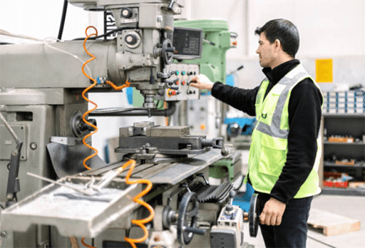 A worker operates a CNC cutting machine